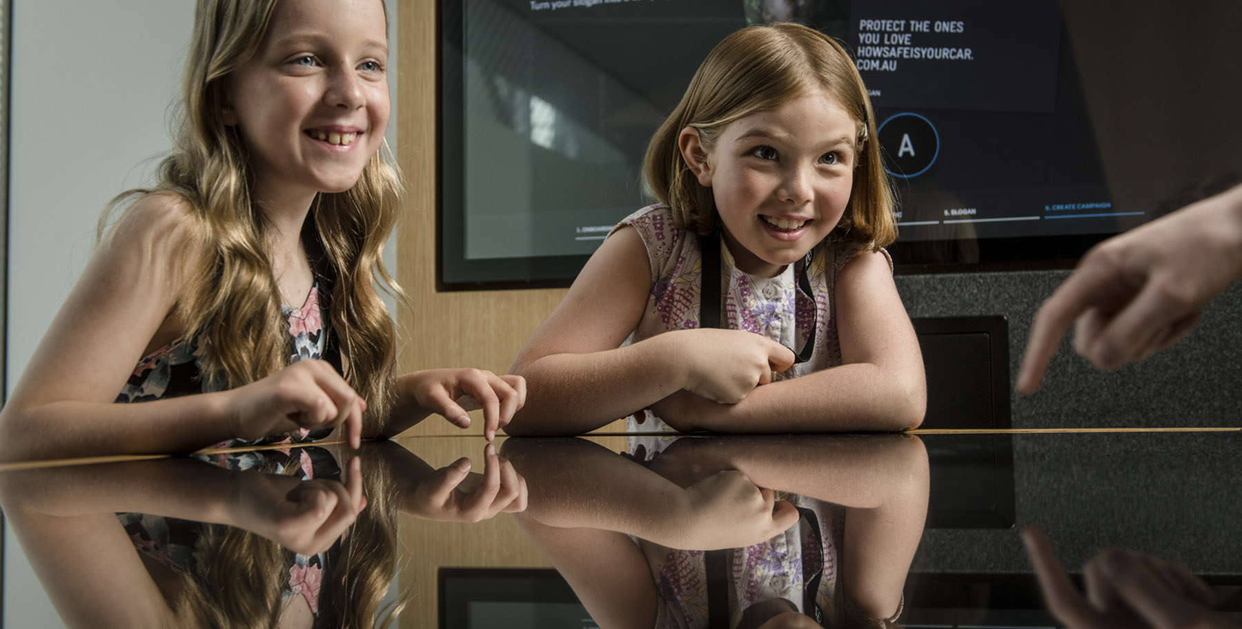 Two children sit at an interactive exhibit
