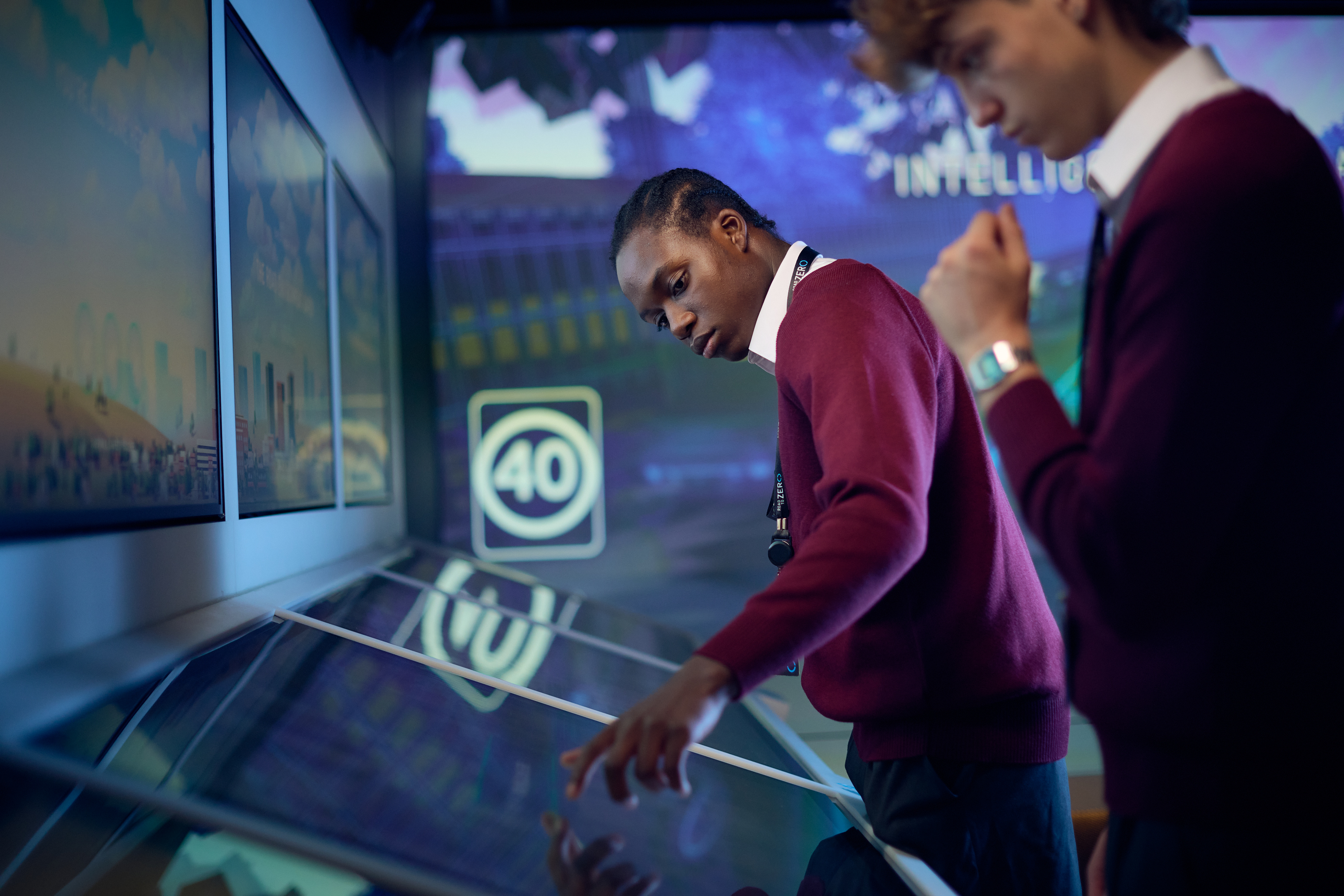 A male teenage student interacts with a screen display